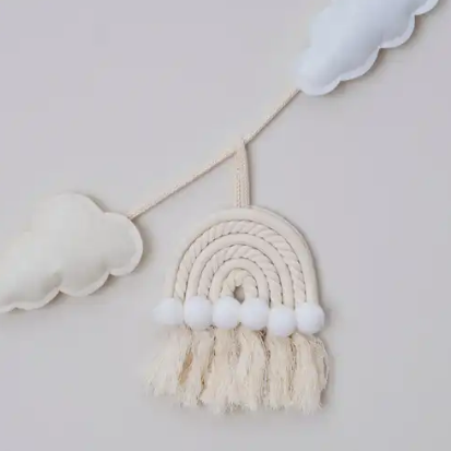 Decorative cloud and rainbow wall hanging on a light gray background