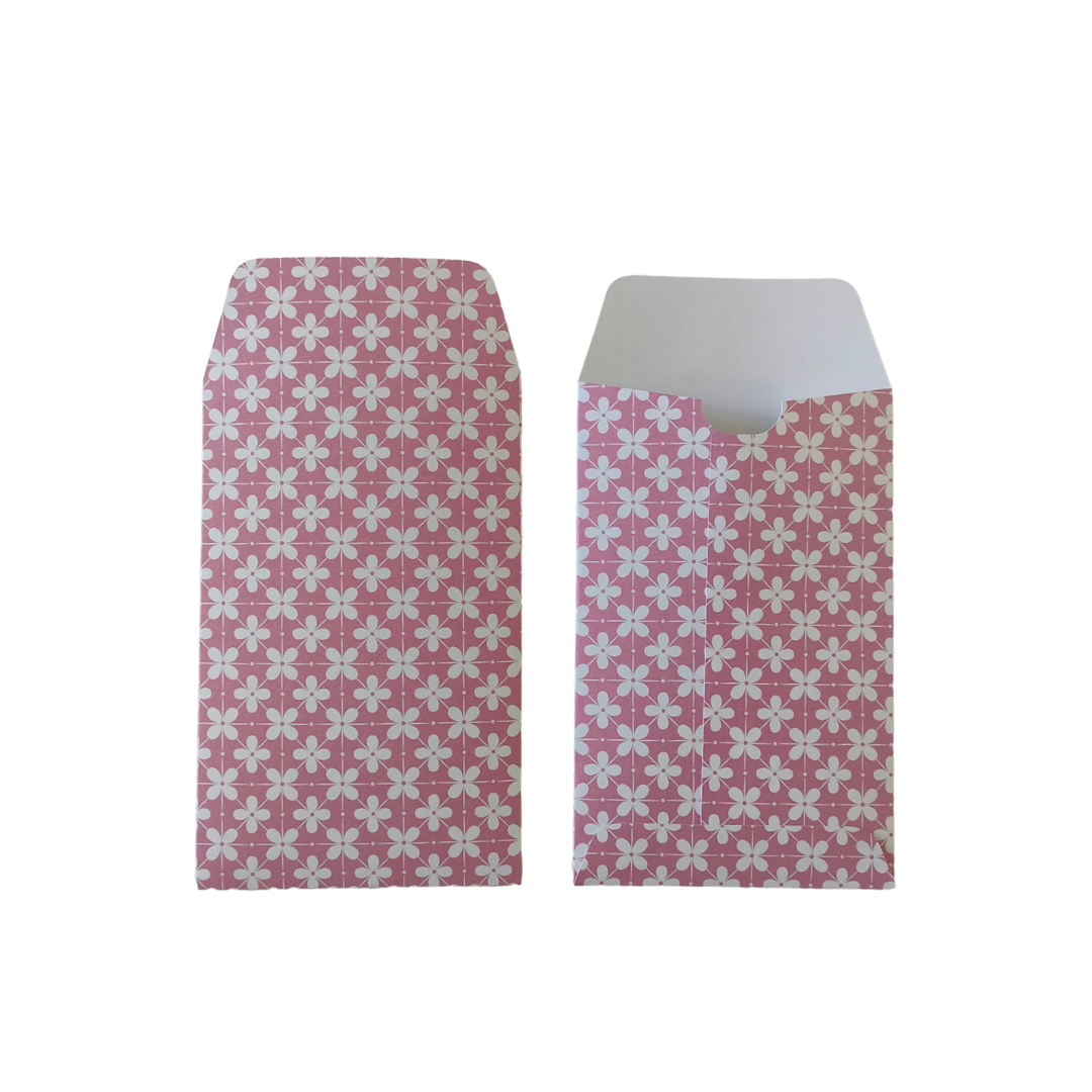 Two pink envelopes with white floral patterns on a white background
