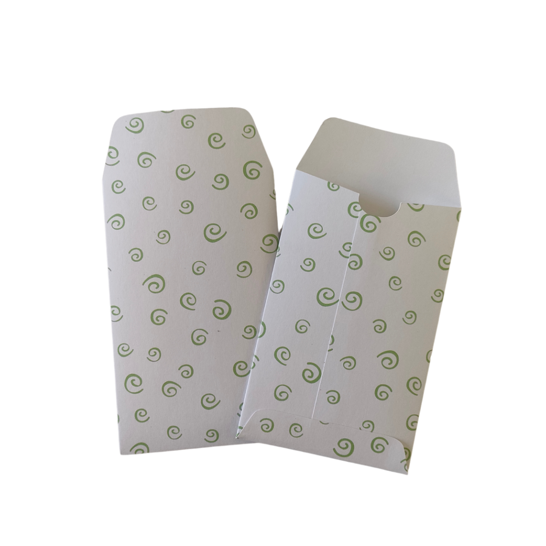 Two white envelopes with green spiral patterns on a white background
