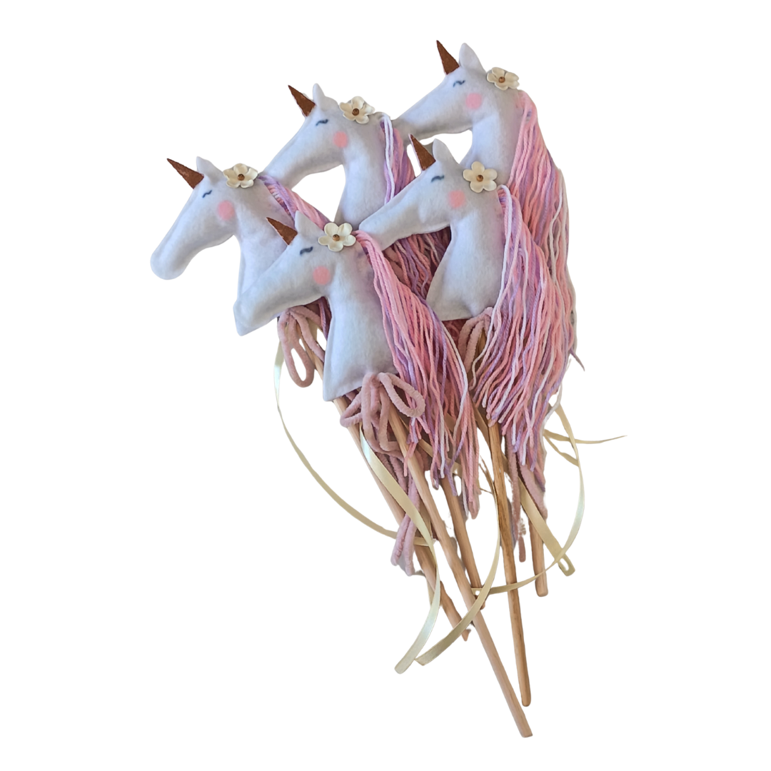 Unicorn-shaped party picks with pink and white hair on a white background