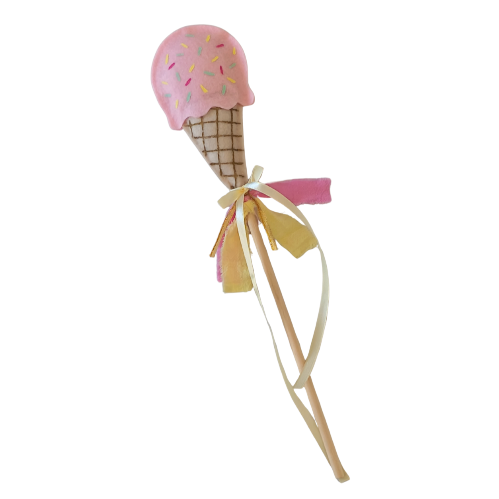 Toy ice cream cone with pink top and sprinkles on a white background