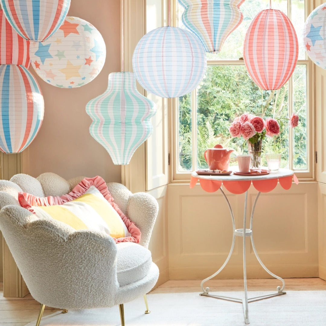 Decorative room with colorful paper lanterns, a chair, and a small table with flowers.